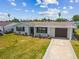 Charming single-story home featuring a well-manicured lawn, attached garage, and a private driveway at 13617 Frances Ave, Hudson, FL 34667