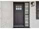 Close-up of the modern front door with glass inserts and dark trim, set against a freshly painted exterior at 13617 Frances Ave, Hudson, FL 34667
