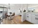 Bright kitchen with hardwood floors and stainless refrigerator, adjacent to a table and living room area at 13617 Frances Ave, Hudson, FL 34667