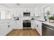 Modern kitchen boasts white cabinets, stainless steel appliances, and sleek countertops at 13617 Frances Ave, Hudson, FL 34667