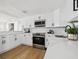 Modern kitchen boasts white cabinets, stainless steel appliances, and sleek countertops at 13617 Frances Ave, Hudson, FL 34667