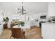 Open-concept kitchen features stainless appliances, stylish light fixture, and views to living area at 13617 Frances Ave, Hudson, FL 34667
