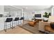 Bright living room with modern furniture, hardwood floors, and a seamless flow to the adjacent kitchen at 13617 Frances Ave, Hudson, FL 34667