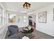 Sunroom with tile floors, chairs and a view of the kitchen at 13617 Frances Ave, Hudson, FL 34667