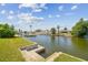 Scenic waterfront view featuring a concrete bank and canal with homes and docked boats in the distance at 13617 Frances Ave, Hudson, FL 34667
