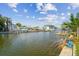 Waterfront view featuring a canal with a concrete bank, a chain link fence, and docked boats in the distance at 13617 Frances Ave, Hudson, FL 34667