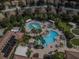 Aerial view of a community resort-style pool area with ample seating, a clubhouse, and lush greenery at 146 Shell Falls Dr, Apollo Beach, FL 33572
