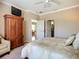 Comfortable bedroom with neutral tones, TV armoire, and access to the bathroom at 146 Shell Falls Dr, Apollo Beach, FL 33572