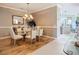 Dining room featuring a glass table, chandelier, and wood-look floors, with access to the kitchen at 146 Shell Falls Dr, Apollo Beach, FL 33572
