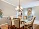 Dining room with a glass table and chairs, neutral walls, and decorative chandelier at 146 Shell Falls Dr, Apollo Beach, FL 33572