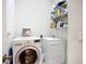 Functional laundry room with washer, dryer, and shelving for storage at 146 Shell Falls Dr, Apollo Beach, FL 33572