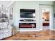 Cozy living room featuring a wall-mounted fireplace, mounted TV, and hardwood flooring at 146 Shell Falls Dr, Apollo Beach, FL 33572