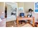 This office features a wooden desk with a rolling chair and decor, with a view looking into the kitchen at 146 Shell Falls Dr, Apollo Beach, FL 33572