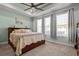 Beautiful bedroom featuring tray ceilings, a ceiling fan, and large windows with lovely, light-filtering curtains at 15429 Caravan Ave, Odessa, FL 33556