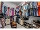 Walk-in closet with wire shelving filled with colorful hanging clothes, laundry hampers and shoe racks at 15429 Caravan Ave, Odessa, FL 33556