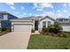 Inviting single-Gathering home featuring a two-car garage, stone accents, and a beautifully landscaped front yard at 15429 Caravan Ave, Odessa, FL 33556