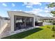 Backyard view of screened-in porch, outdoor dining table, hot tub and well-manicured lawn at 15429 Caravan Ave, Odessa, FL 33556