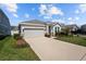 Beautiful home with manicured lawn, stone accents, a two-car garage, and modern design elements at 15429 Caravan Ave, Odessa, FL 33556