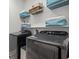 Laundry room featuring a modern, front-loading washer and dryer with ample storage space at 15429 Caravan Ave, Odessa, FL 33556