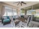 Inviting screened patio with comfortable seating, ceiling fan, and access to the backyard at 15429 Caravan Ave, Odessa, FL 33556