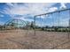 View of the community playground with climbing net, rope bridge, and swings with a wood chip surface at 15429 Caravan Ave, Odessa, FL 33556