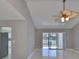 Living room with tile floors, high ceiling with ceiling fan, and sliding glass door to outdoor patio at 1806 Wolf Laurel Dr, Sun City Center, FL 33573