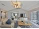 Bright living room featuring neutral tones, vaulted ceiling, and sliding glass doors offering views of the outdoors at 1806 Wolf Laurel Dr, Sun City Center, FL 33573