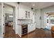 Elegant wet bar featuring white cabinetry, marble counters, and wine refrigerator at 182 E Canal Dr, Palm Harbor, FL 34684