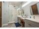 Bathroom featuring double sinks, gray cabinetry, marble countertops, and a glass-enclosed shower at 182 E Canal Dr, Palm Harbor, FL 34684