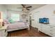 Charming bedroom with hardwood floors, ceiling fan, and a fish tank on a white dresser at 182 E Canal Dr, Palm Harbor, FL 34684
