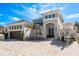 Stunning two-story home featuring a gray exterior, double doors, manicured landscaping, and a brick driveway at 182 E Canal Dr, Palm Harbor, FL 34684