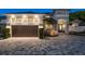 Elegant two-story home with a manicured lawn, paver driveway, and attached garage at 182 E Canal Dr, Palm Harbor, FL 34684