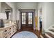 Inviting foyer with a wooden accent wall, hardwood floors, statement mirror, and stylish decor at 182 E Canal Dr, Palm Harbor, FL 34684