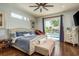 Bright main bedroom with wood floors, ceiling fan, and sliding glass doors leading to a pool at 182 E Canal Dr, Palm Harbor, FL 34684