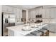 Modern kitchen with stainless steel appliances, a central island, and elegant countertops and backsplash at 1880 Longliner Loop, Wesley Chapel, FL 33543