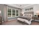 Serene primary bedroom featuring plush carpet, large windows, tray ceiling, and stylish decor at 1880 Longliner Loop, Wesley Chapel, FL 33543