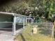 View of the fenced backyard including the patio, storage shed and greenery at 2001 E Powhatan Ave, Tampa, FL 33610
