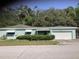 Inviting single-story home with a covered entrance, attached garage, and manicured shrubbery at 2001 E Powhatan Ave, Tampa, FL 33610