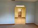 Hallway featuring light tile flooring and views into the carpeted living room and a yellow colored room at 2001 E Powhatan Ave, Tampa, FL 33610