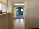Hallway featuring light tile flooring and views into the carpeted living room and a yellow colored room at 2001 E Powhatan Ave, Tampa, FL 33610