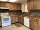 A kitchen with wood cabinets, white appliances, and a tiled backsplash provides a functional space at 2001 E Powhatan Ave, Tampa, FL 33610