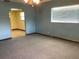 Carpeted living room featuring neutral carpeting, ample natural light, and a ceiling fan at 2001 E Powhatan Ave, Tampa, FL 33610