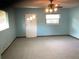 Bright living room featuring neutral carpeting, ample natural light, and a ceiling fan at 2001 E Powhatan Ave, Tampa, FL 33610