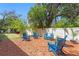 A lawn with mulch is decorated with blue Adirondack chairs and landscaping against a fenced perimeter at 207 S Coolidge Ave, Tampa, FL 33609