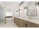 Modern bathroom featuring double sinks, a soaking tub, and modern lighting fixtures at 207 S Coolidge Ave, Tampa, FL 33609