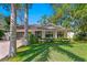 Charming home features a well-manicured lawn and inviting front porch with decorative pillars at 207 S Coolidge Ave, Tampa, FL 33609