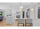 Modern kitchen with white cabinets, stainless appliances, and a breakfast bar with stylish pendant lighting at 207 S Coolidge Ave, Tampa, FL 33609