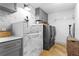 Functional laundry room featuring a dog wash station, gray cabinets and modern washer and dryer units at 207 S Coolidge Ave, Tampa, FL 33609