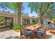 A dining table and patio furniture sit on a brick patio, surrounded by lush greenery and a home exterior at 207 S Coolidge Ave, Tampa, FL 33609