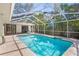 Inviting pool area with turquoise water, screened enclosure, and lush tropical landscaping at 207 S Coolidge Ave, Tampa, FL 33609